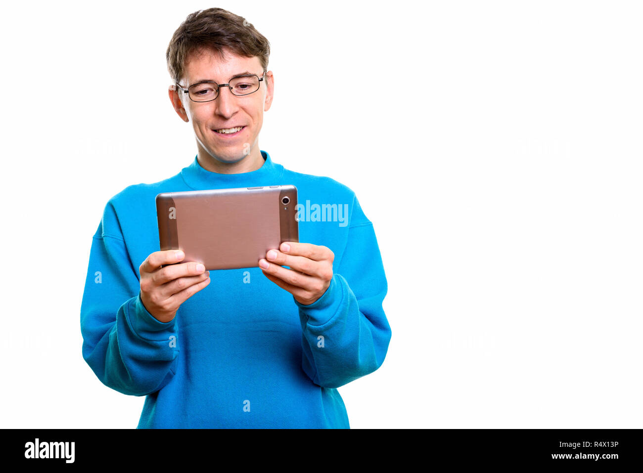 Studio shot of happy man smiling while using digital tablet Banque D'Images