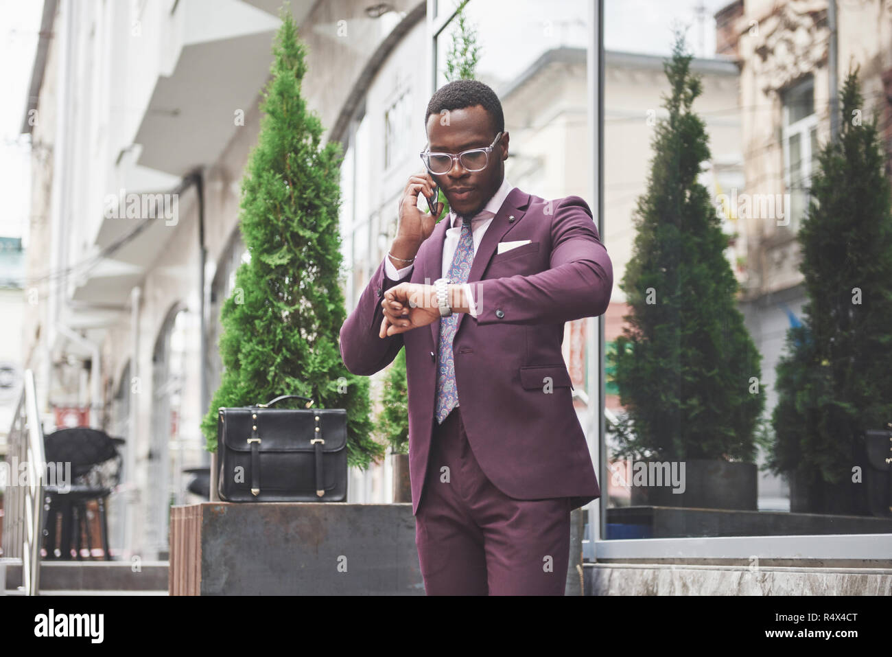 Portrait d'un jeune et beau African American Woman in a suit par téléphone. La préparation pour une réunion d'affaires. Banque D'Images