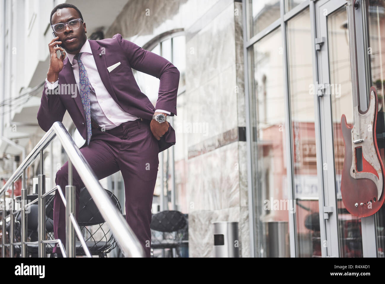 Portrait d'un jeune et beau African American Woman in a suit par téléphone. La préparation pour une réunion d'affaires. Banque D'Images