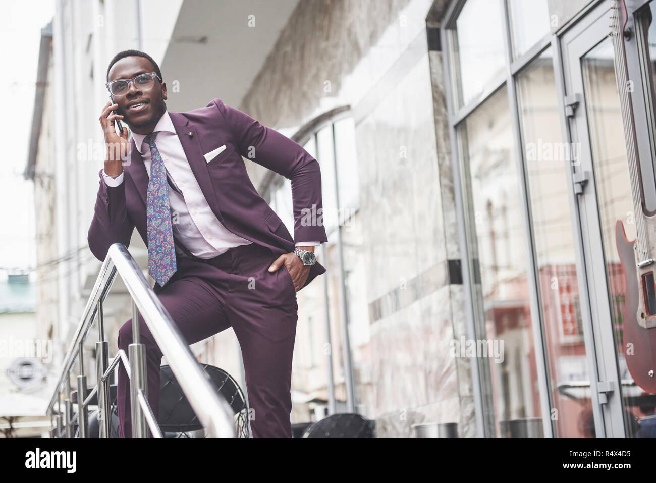 Portrait d'un jeune et beau African American Woman in a suit par téléphone. La préparation pour une réunion d'affaires. Banque D'Images