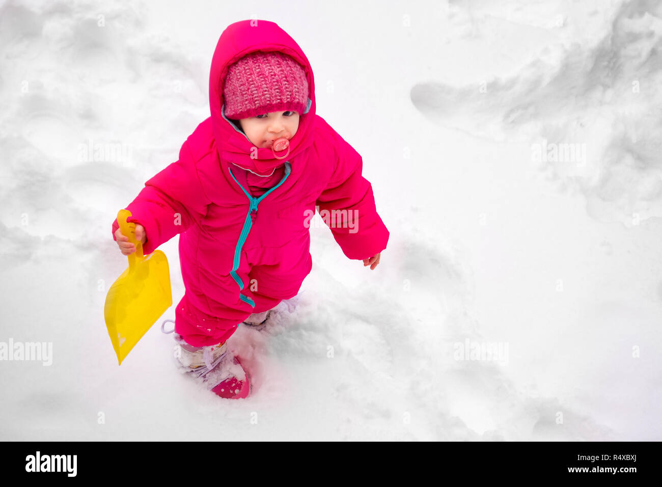 Little baby girl voir jouer la neige hiver combinaison de ski enfant wearpink Banque D'Images