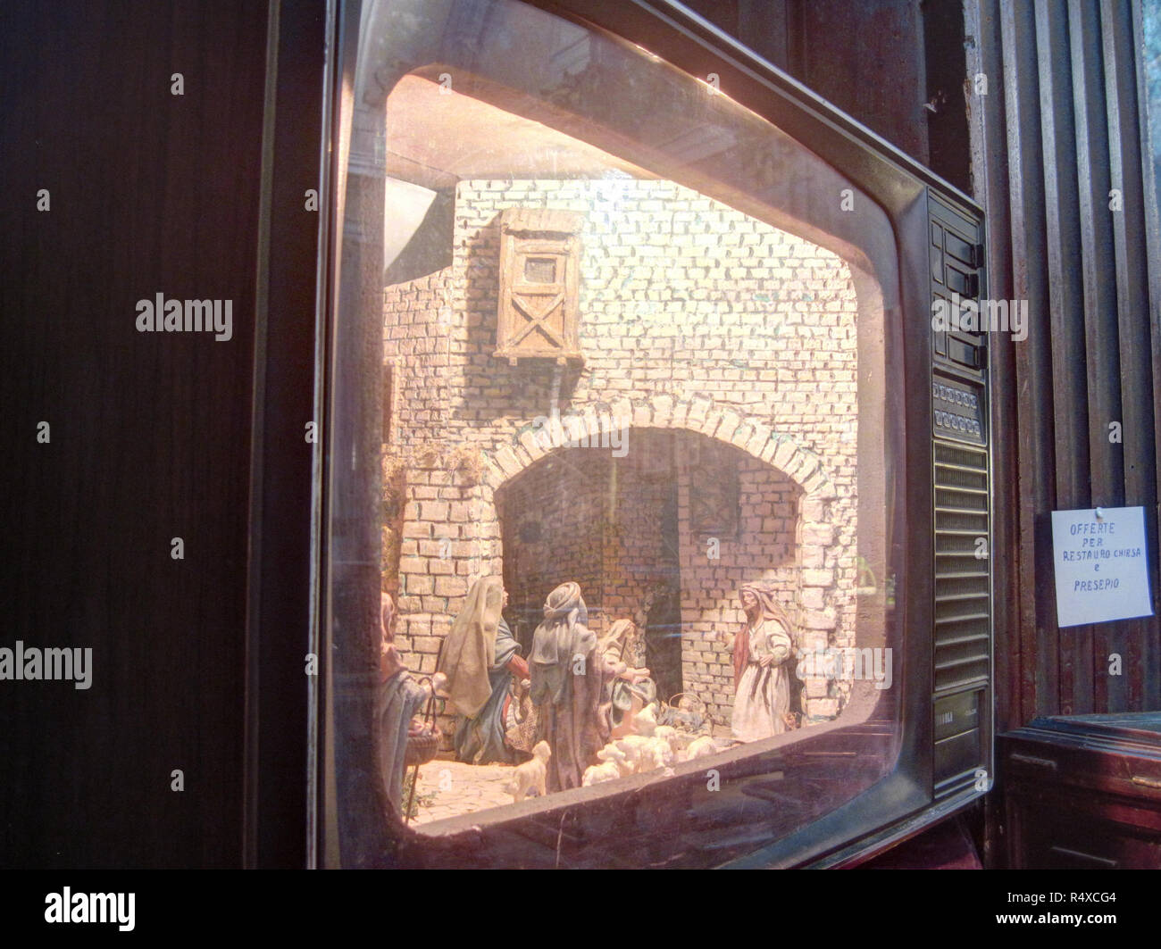 Une crèche de Noël italien (im) avec bâtiment miniature représentée à l'intérieur une vieille télévision à tube cathodique Banque D'Images