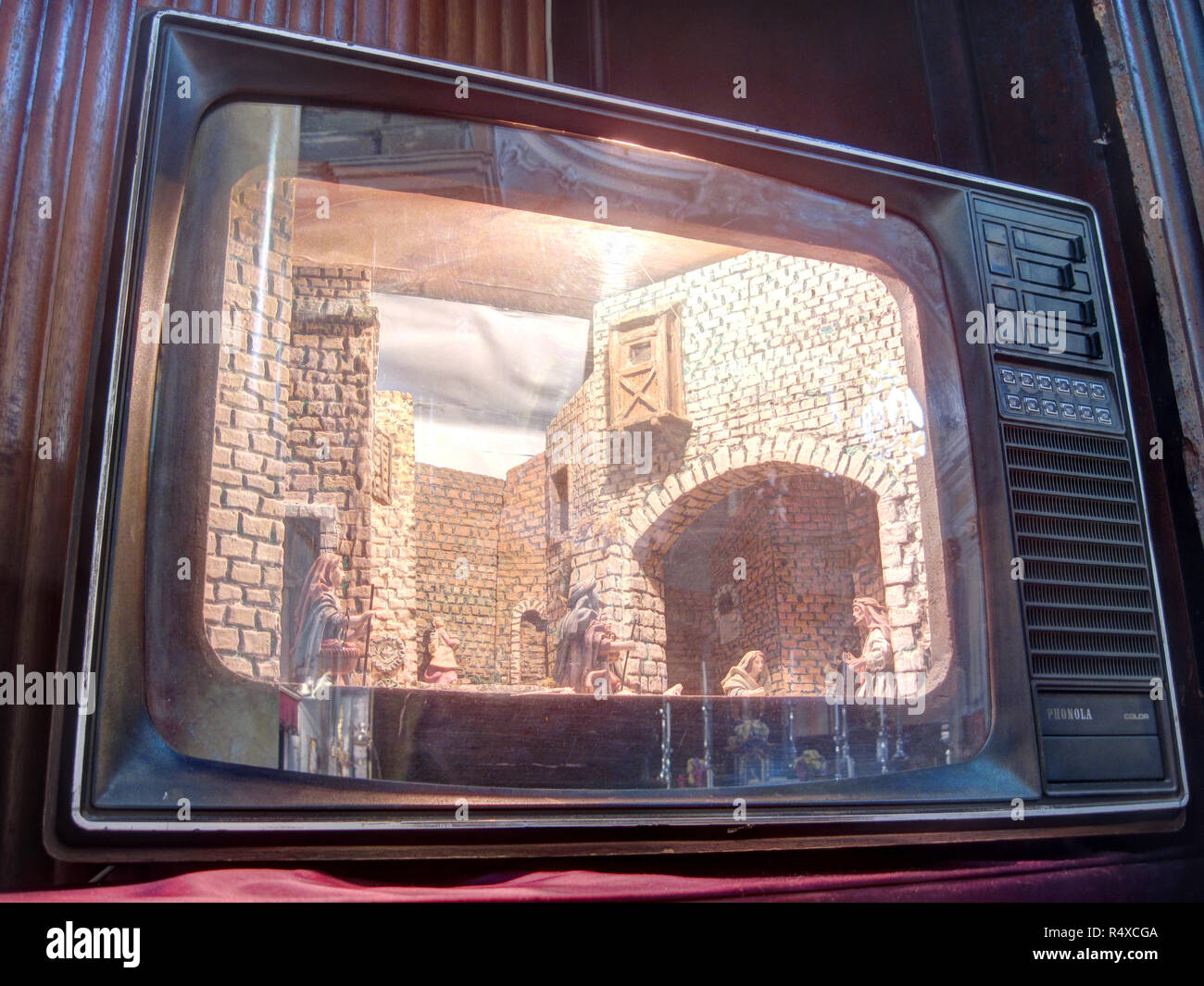 Une crèche de Noël italien (im) avec bâtiment miniature représentée à l'intérieur une vieille télévision à tube cathodique Banque D'Images