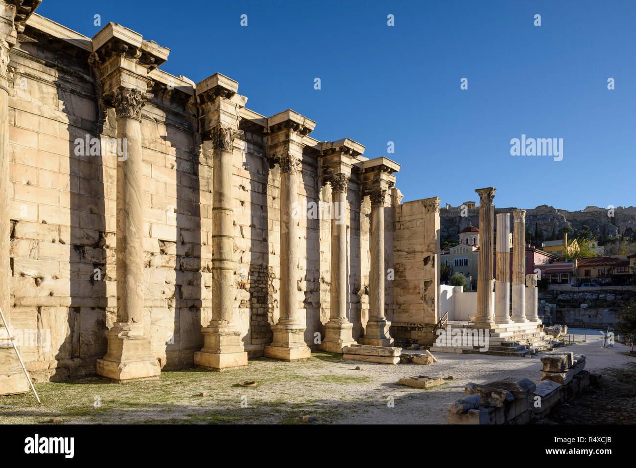 Athènes. La Grèce. Reste du mur ouest de la bibliothèque d'Hadrien, créé par l'empereur romain Hadrien en 132 AD, l'Acroplois visible dans l'arrière-plan. Banque D'Images