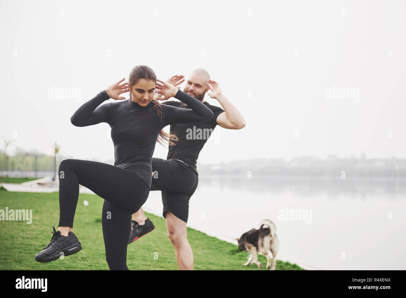 Un jeune couple aime jouer au sport dans la matinée à l'air libre. Réchauffer avant l'exercice Banque D'Images