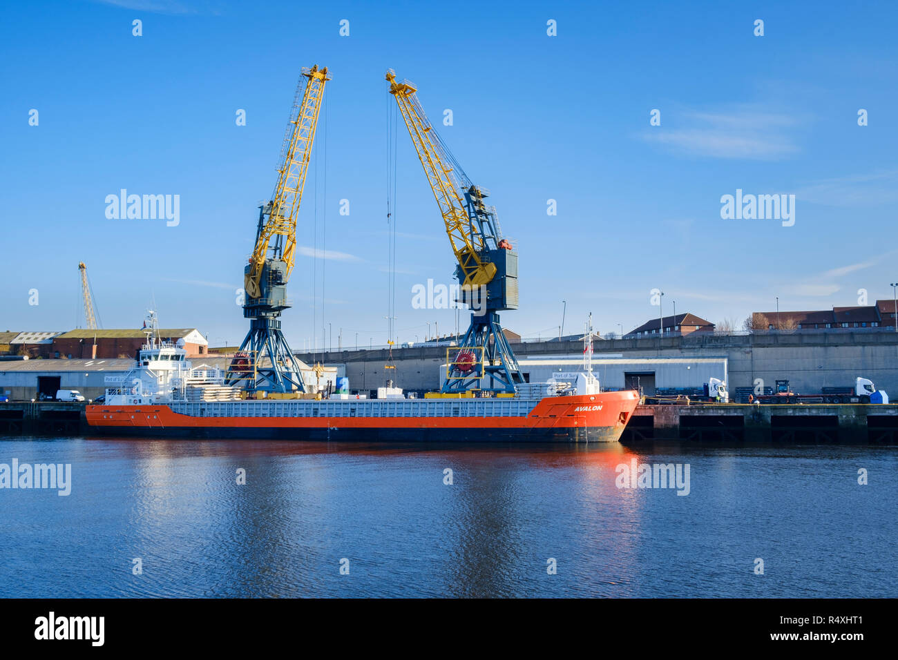 Importation - Exportation - Port de Sunderland grues sur le quai de chargement sur la rivière Wear cargo cargo général Avalon MV d'un navire de commerce construit en 2009 Banque D'Images
