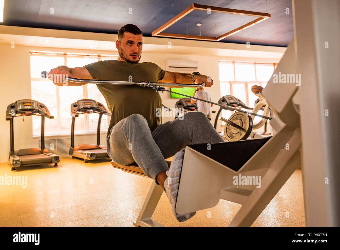 Jeune homme musclé ne partie inférieure de la poitrine exercices avec la machine dans une salle de sport moderne Banque D'Images