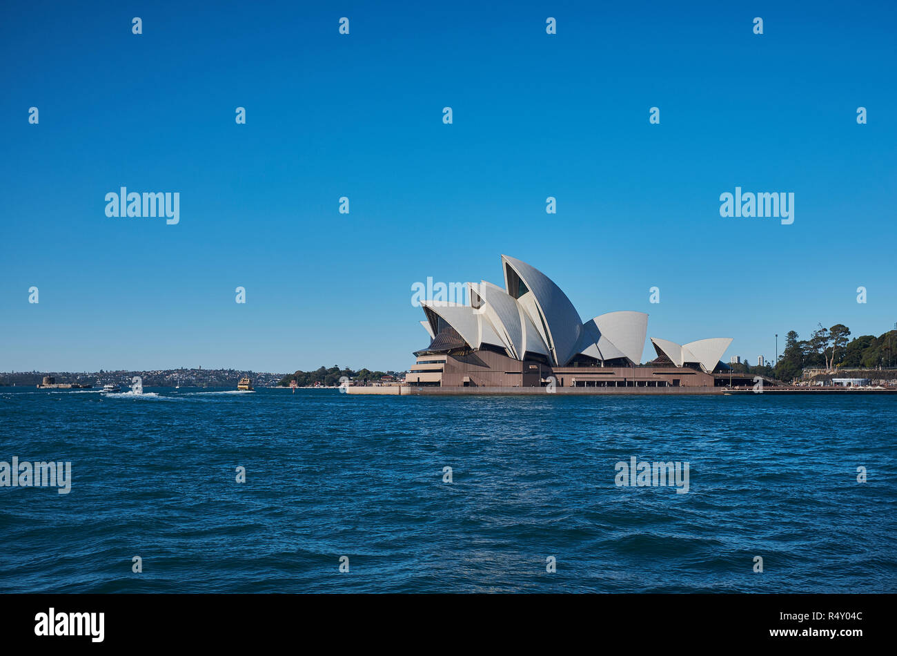 L'Opéra de Sydney à distance avec de l'eau dans l'avant-plan et un ciel bleu en arrière-plan sur une journée d'automne, Sydney, NSW, Australie Banque D'Images