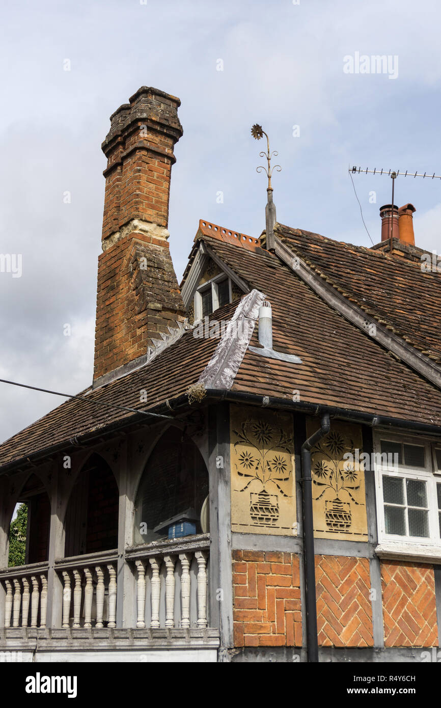 Vieux cottage avec panneaux de sgraffites décorée de tournesols et un balcon romantique par Edward Harris Swinfen, Buckingham, Royaume-Uni Banque D'Images