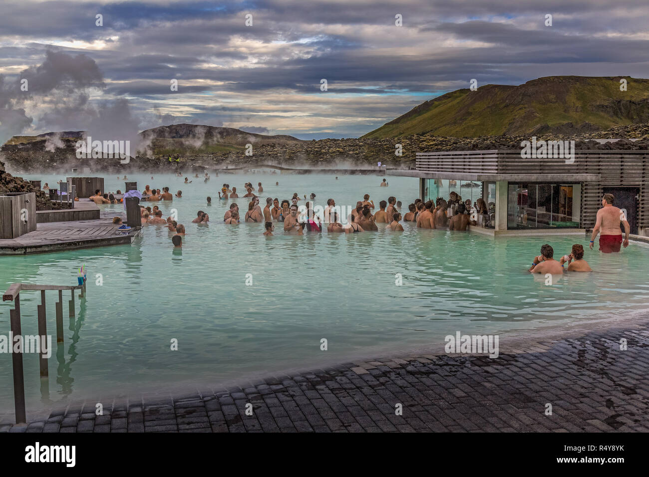Les touristes appréciant les eaux à la spa géothermal Blue Lagoon en Islande, situé dans un champ de lave près de Grindavík sur la péninsule de Reykjanes. Banque D'Images