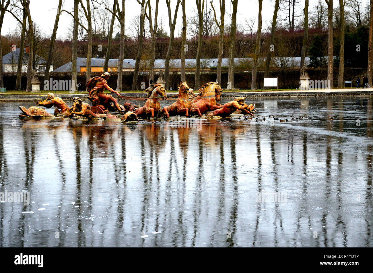 Fontaine d'Apollon, Château de Versailles. Sur une eau gelée, reflet de la fontaine d'Apollon avec des arbres sur une journée d'hiver. Banque D'Images