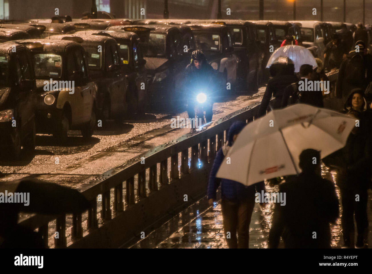 Londres, Royaume-Uni. 28 Nov, 2018. Des taxis noirs bloquer le pont de Londres pour une troisième nuit, et malgré les mauvais temps, dans le cadre de leur Taxi protester contre la décision de TfL de conduire en bloc où les bus sont autorisés - comme dans la rue Tooley et Bnak Junction. Crédit : Guy Bell/Alamy Live News Banque D'Images