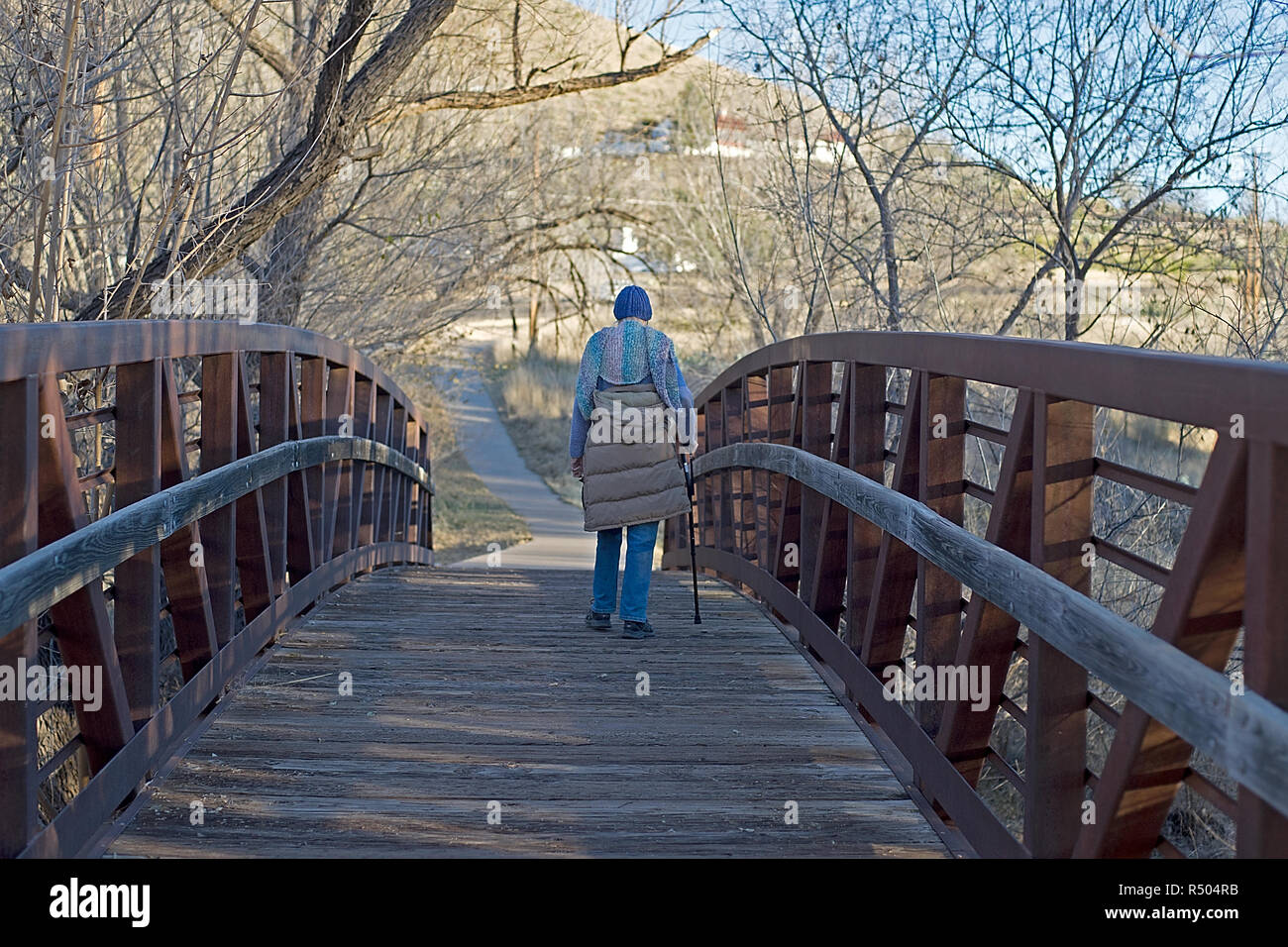Senior citizen femme marche sur un pont piétonnier de Alpine, Texas. Banque D'Images