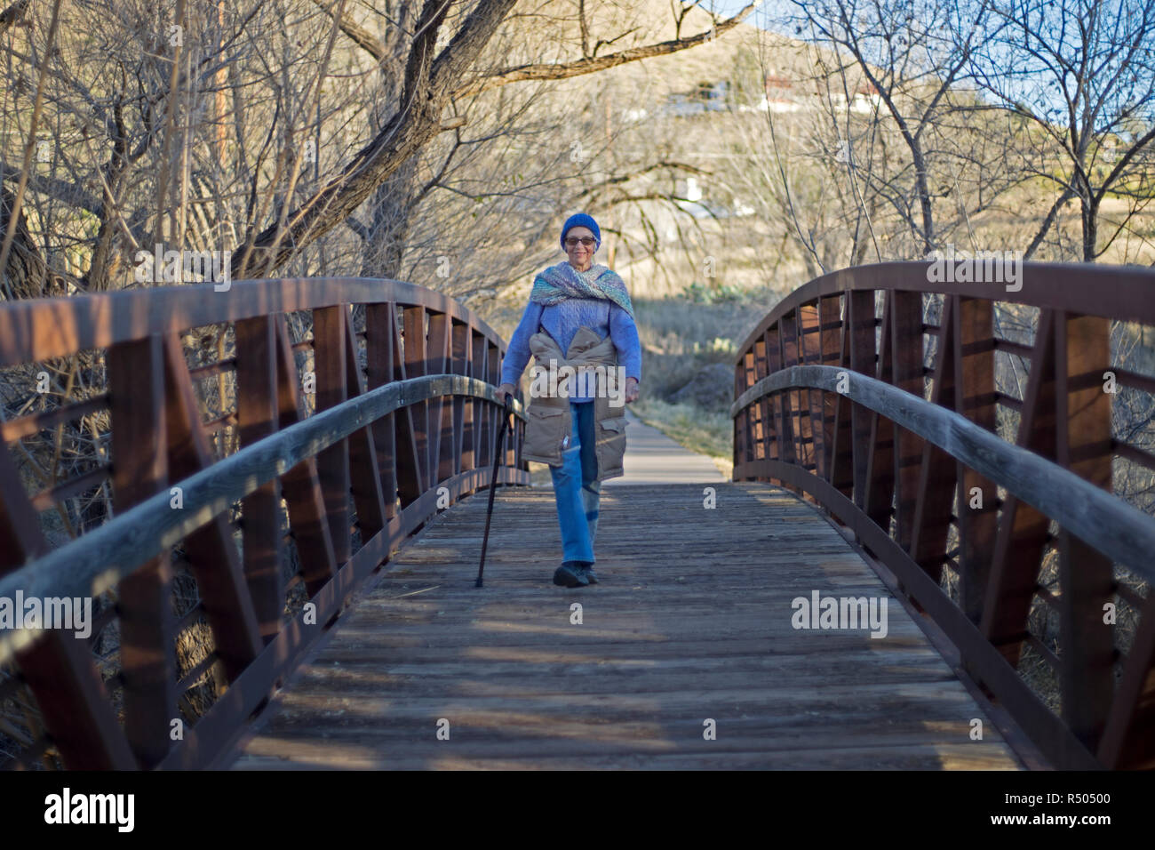 Senior citizen femme marche sur un pont piétonnier de Alpine, Texas. Banque D'Images