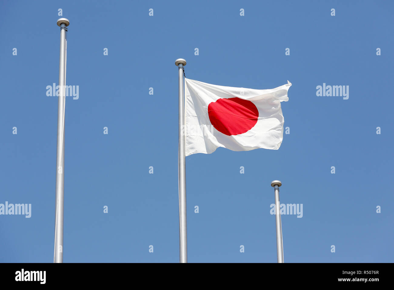 Drapeau japonais en vent contre ciel bleu clair Banque D'Images