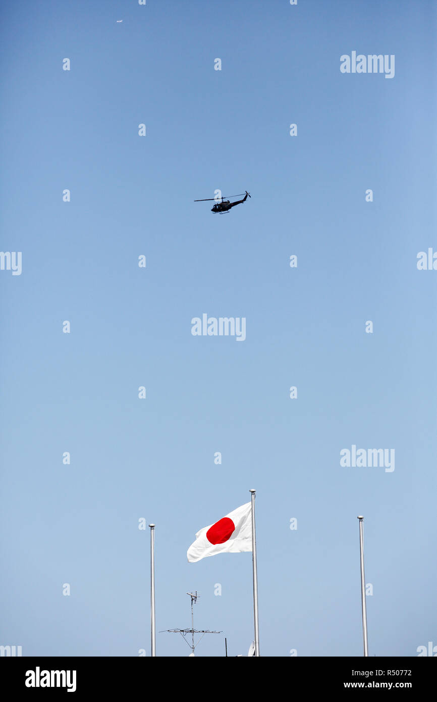 Drapeau japonais dans le vent avec un hélicoptère militaire Banque D'Images