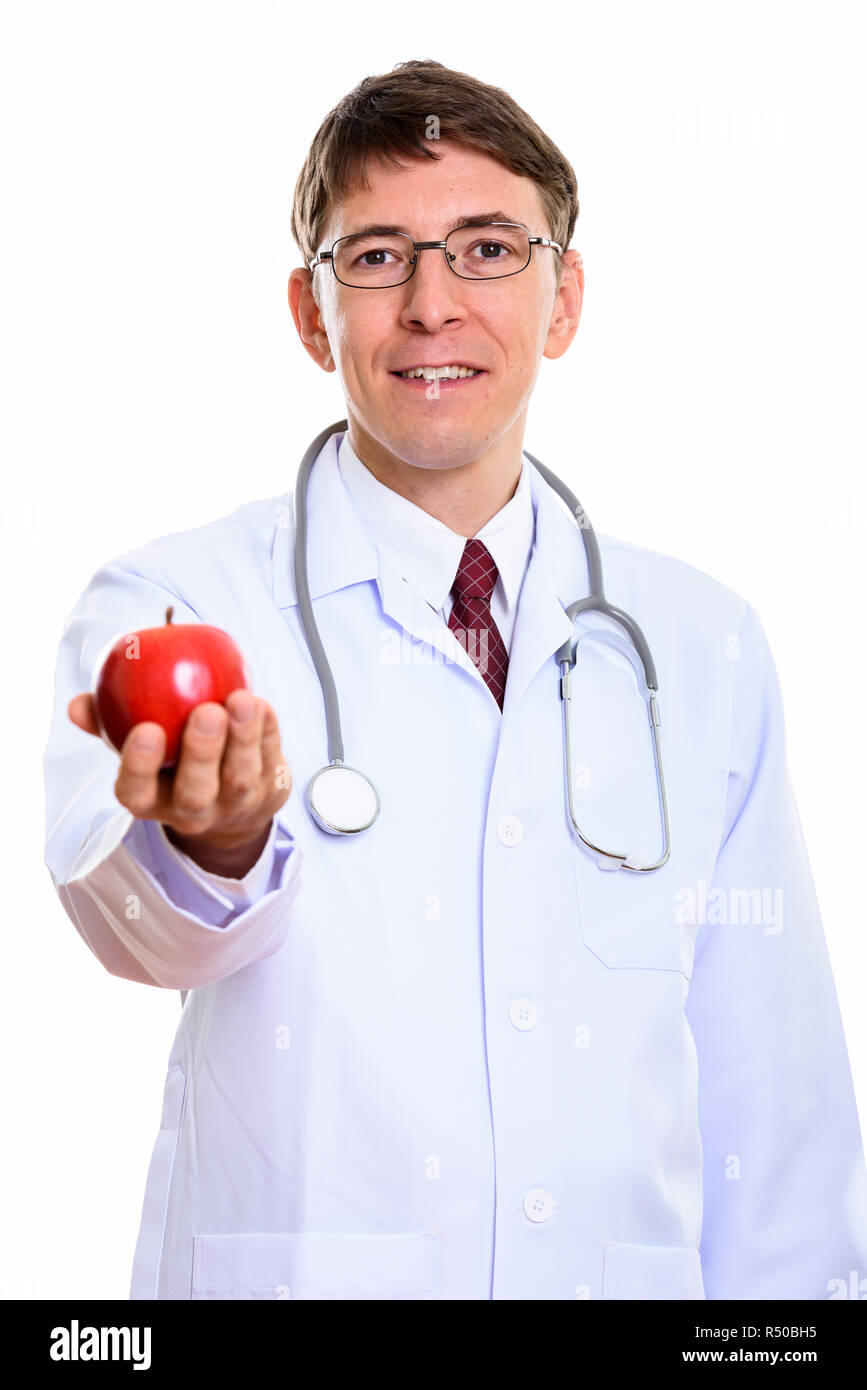 Studio shot of happy man smiling médecin tout en donnant la pomme rouge Banque D'Images