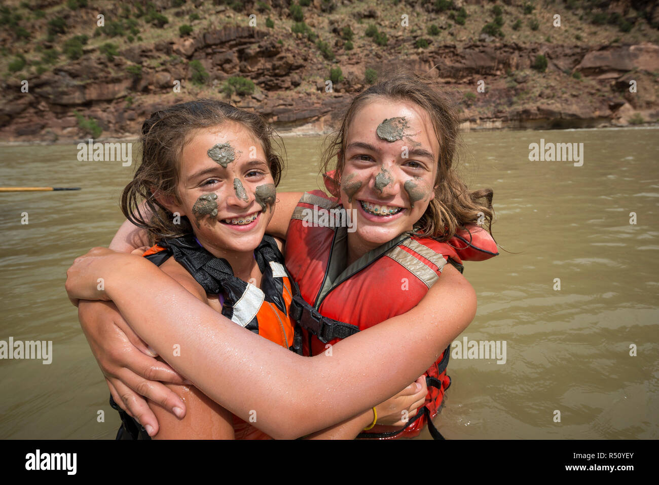 Deux enfants jouant dans la rivière et la peinture de la boue sur chacune des autres faces lors d'un voyage de rafting de la rivière Verte, la Désolation/Gris section Canyon, Utah, USA Banque D'Images