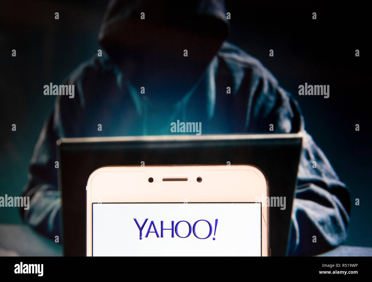 Fournisseur de services web société américaine Yahoo ! Logo est vu sur un appareil mobile Android avec une figure de hacker dans l'arrière-plan. Banque D'Images