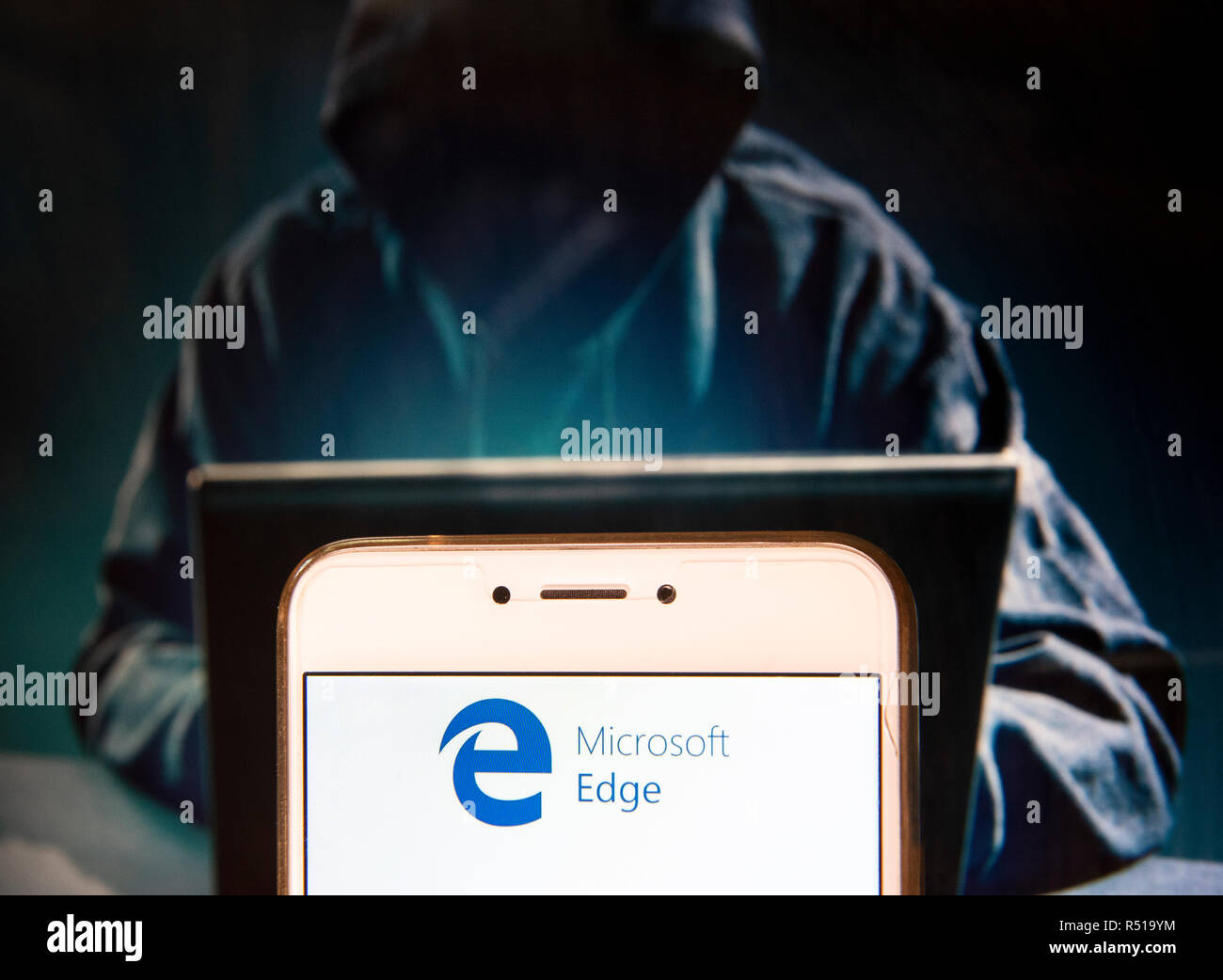 American navigateur web développé par Microsoft, le logo Microsoft Edge,l est vu sur un appareil mobile Android avec une figure de hacker dans l'arrière-plan. Banque D'Images