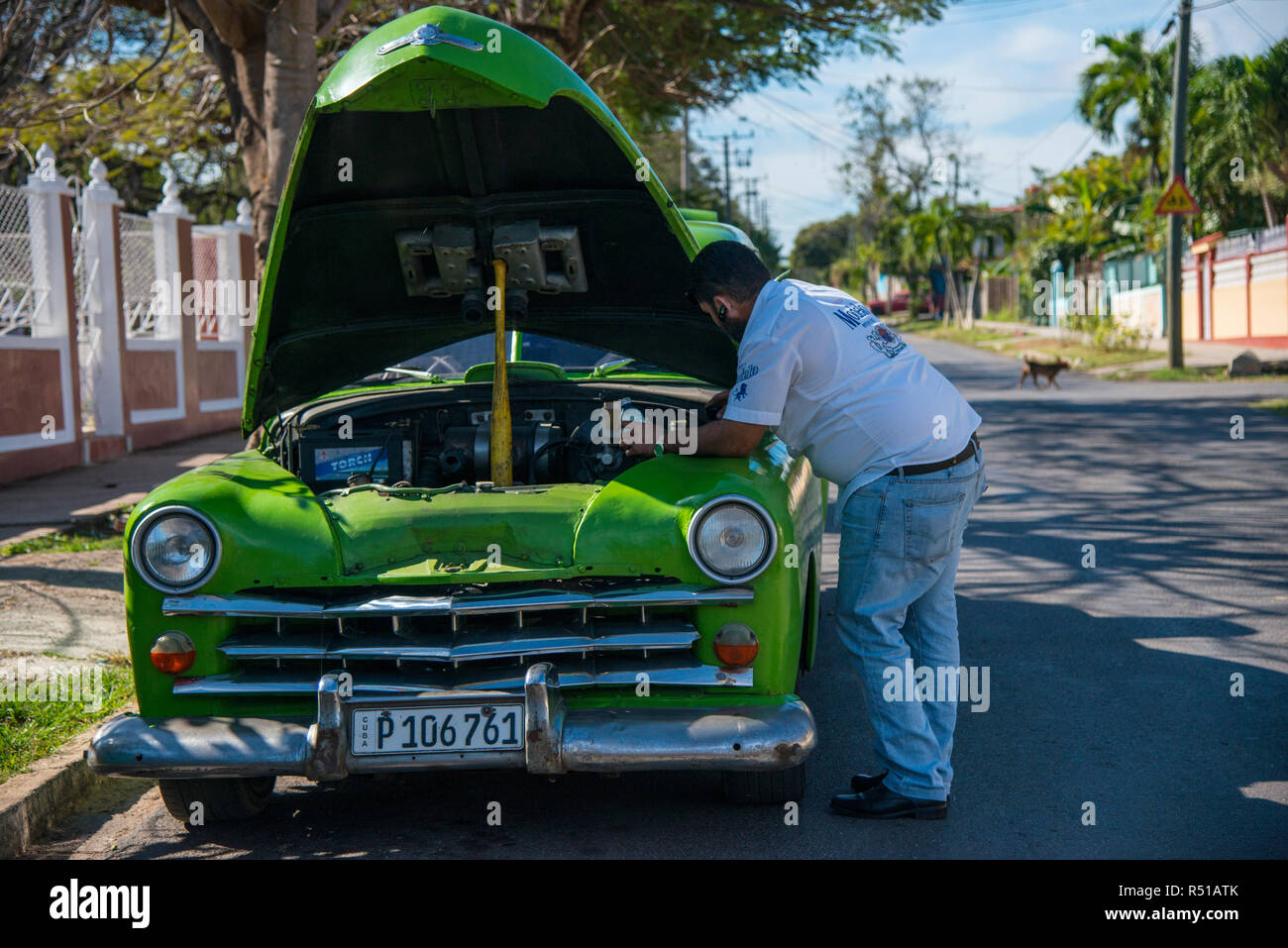 À l'aide d'un bâton de baseball pour ouvrir le capot pour la réparation sur voiture 50s. Banque D'Images