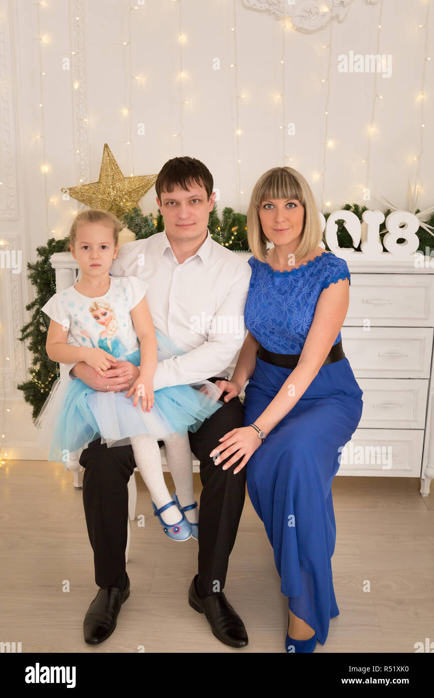 Jeune famille avec sa fille dans une chambre décorée pour Noël Banque D'Images