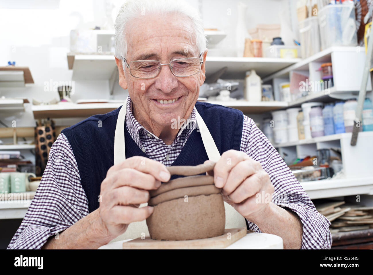 Man Faire Pot de la bobine dans un atelier de poterie Banque D'Images