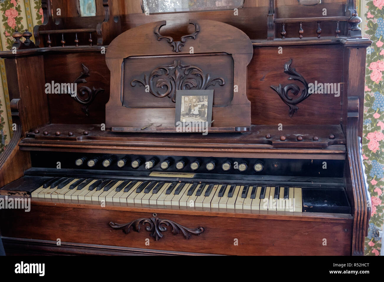 Pompe d'orgue avec boutons et son clavier de piano. Photo ancienne vintage  & mur floral papier. Historique de l'intérieur de la maison, Texan McKinney  Photo Stock - Alamy
