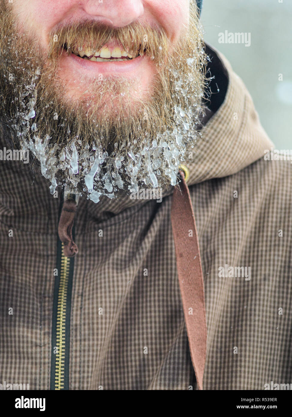Beard dans les glaçons. Partie du visage d'un jeune homme dans un veston brun. Concept de sports d'hiver à l'air libre. Banque D'Images