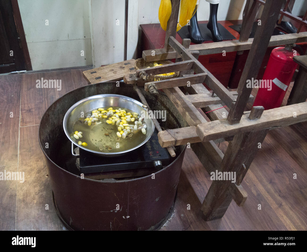 Les larves de vers à soie pour bouillir le pot pour extraire des fils de soie de soie en Asie Vietnam Hoi An en usine Banque D'Images