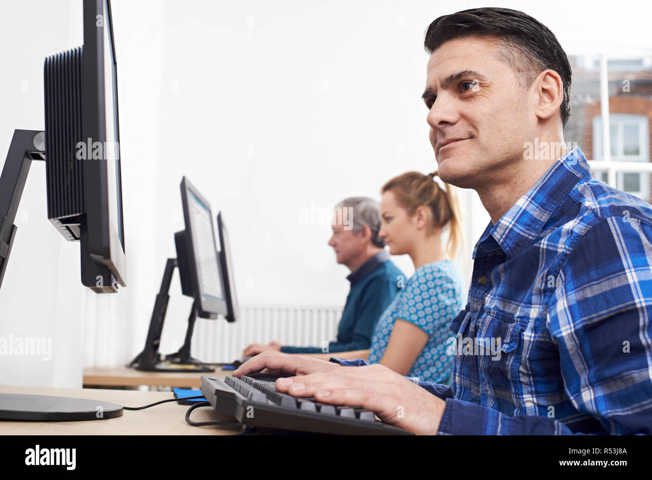 Homme mûr qui fréquentent la classe de l'ordinateur en face de l'écran Banque D'Images