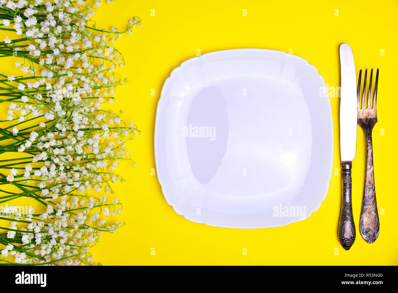 La plaque de fer blanc et de coutellerie sur fond jaune Banque D'Images