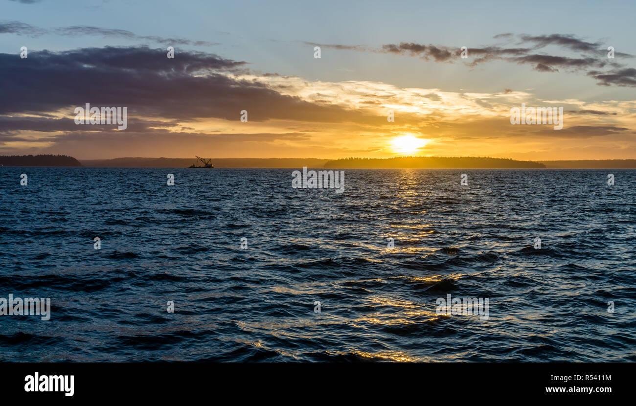 Vue d'un navire Crane et golden coucher du soleil sur le Puget Sound à l'Ouest de Seattle, Washington. Banque D'Images