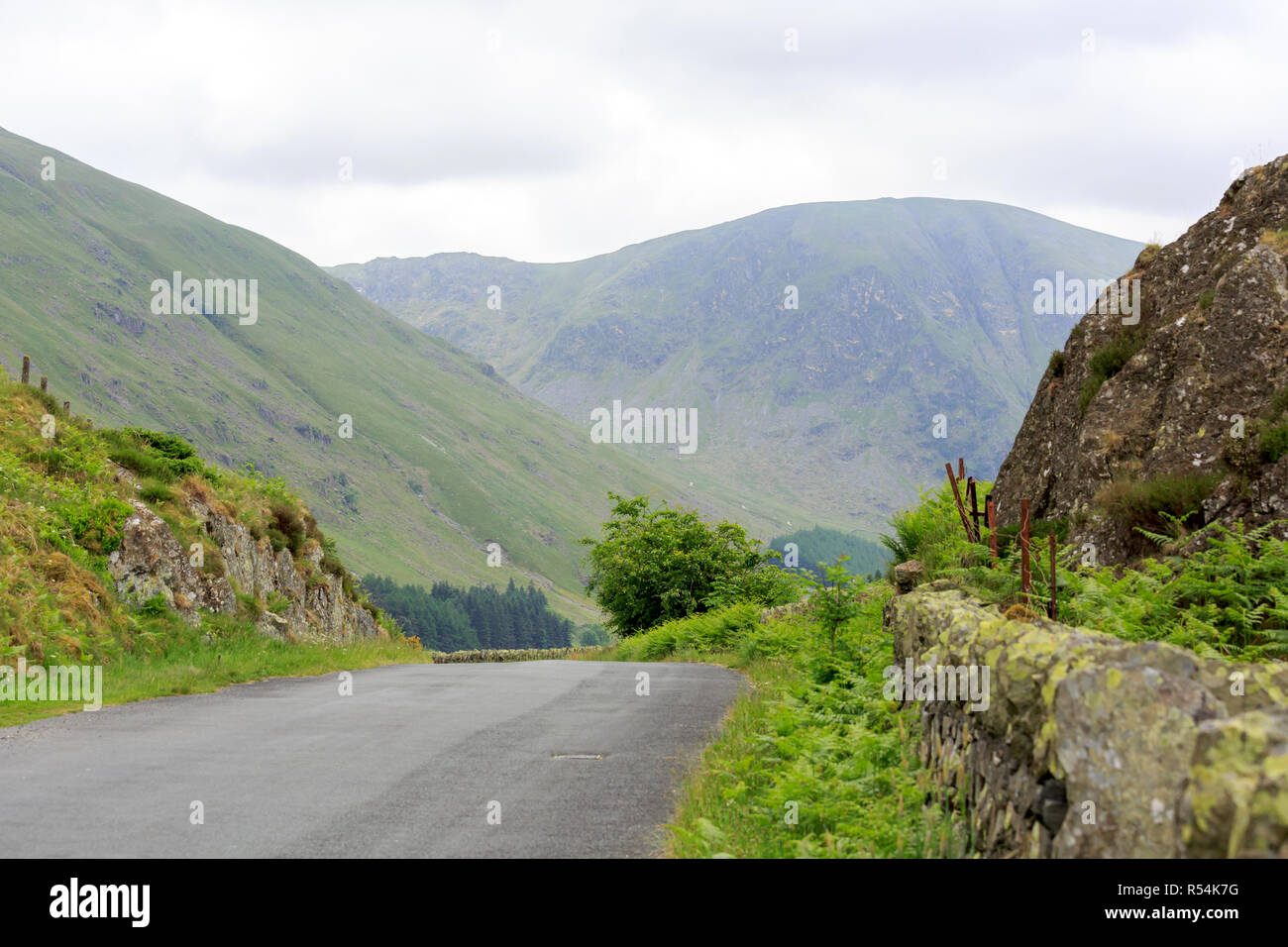 Une route bordée d'un mur de pierre dans le collines de Cumbrie Banque D'Images