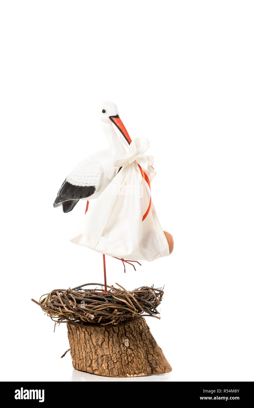 Stork décoratif en tenant bébé bec nappy et debout dans l'osier nest isolated on white Banque D'Images