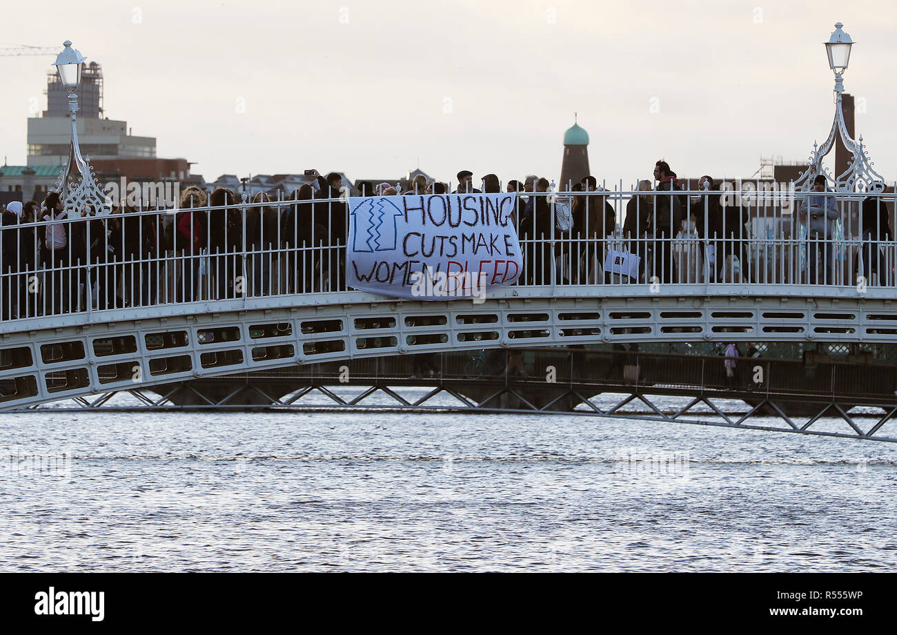 Les membres de la campagne Take back the City Group déploie une bannière sur le Ha'penny Bridge à Dublin pour mettre en évidence les expériences des personnes sans abri en raison de la violence domestique. Banque D'Images