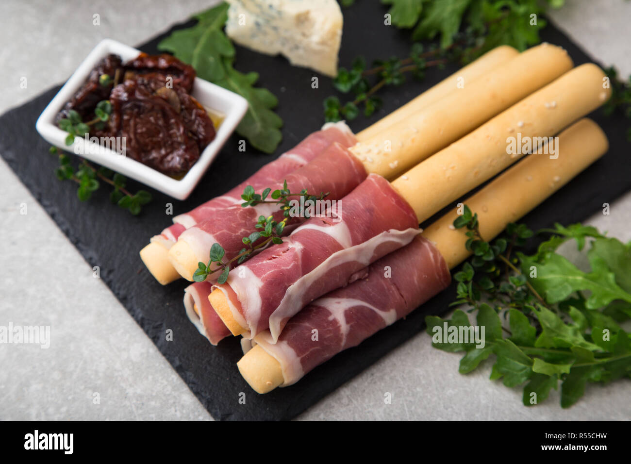 Apéritif avec prosciutto, jambon, fromage bleu et tomates séchées au soleil pour les vacances Banque D'Images