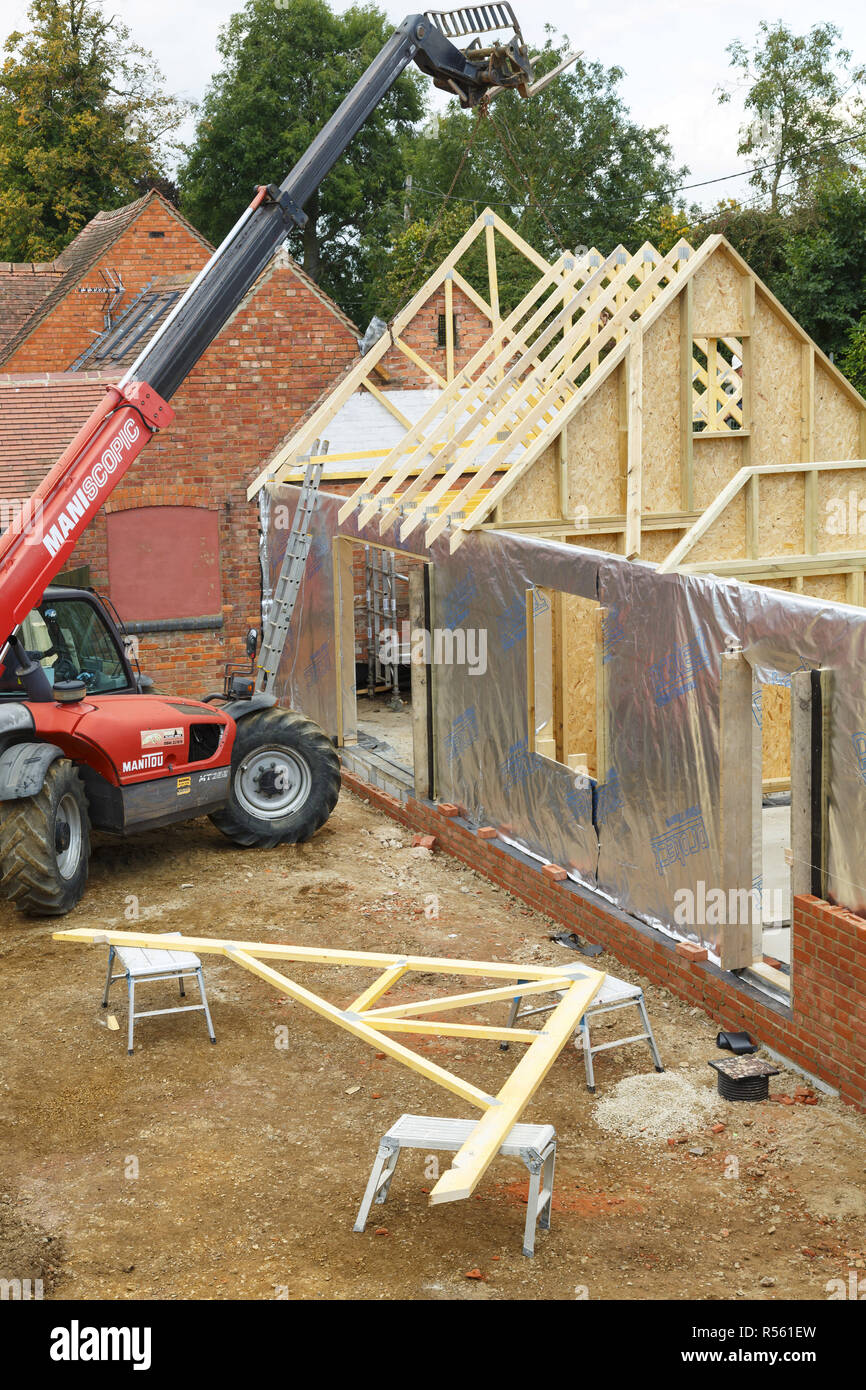 Buckingham, Royaume-Uni - Octobre 13, 2016. La machinerie lourde est utilisée pour ajouter les fermes de toit d'une maison à ossature bois extension dans le Buckinghamshire, Royaume-Uni Banque D'Images
