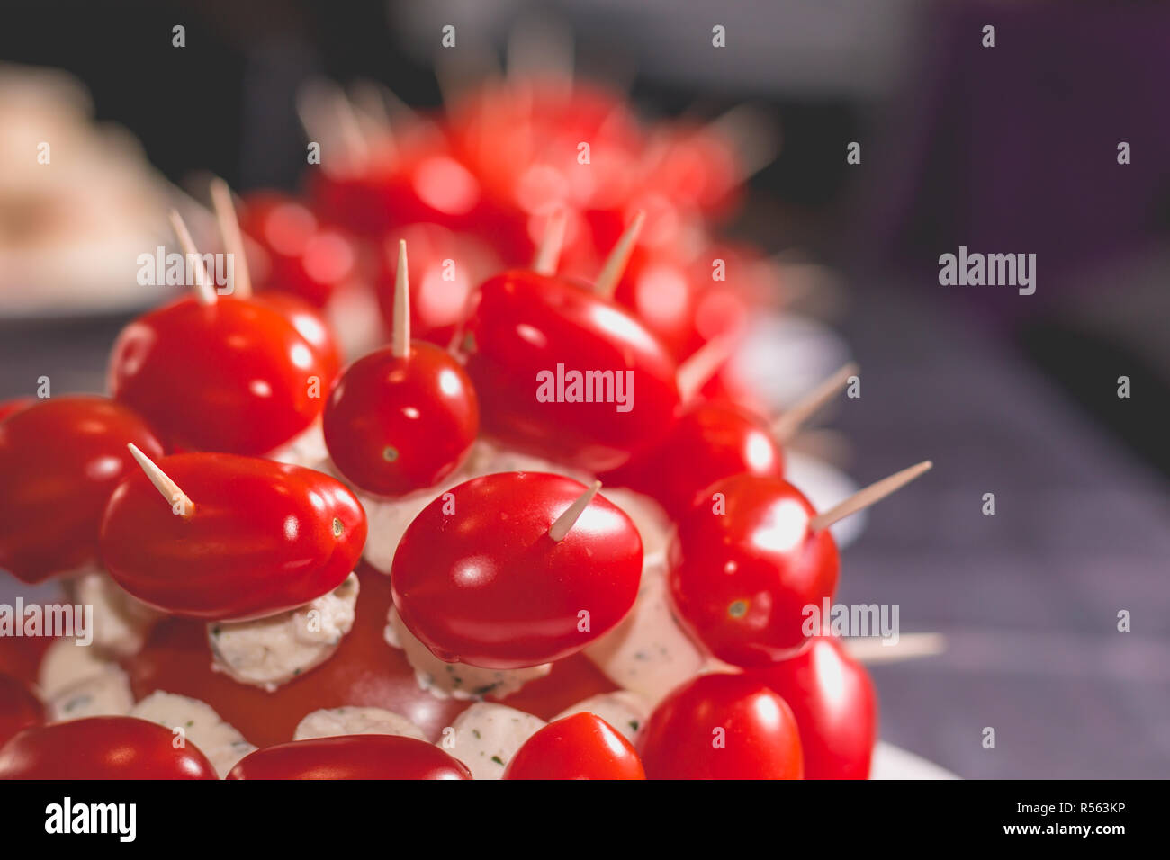 Tomates Cocktail avec du fromage sur le pic sur une plaque Banque D'Images