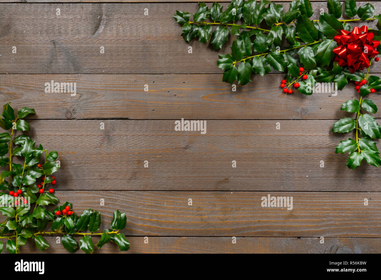 Houx de Noël aux fruits rouges sur un fond de bois Banque D'Images