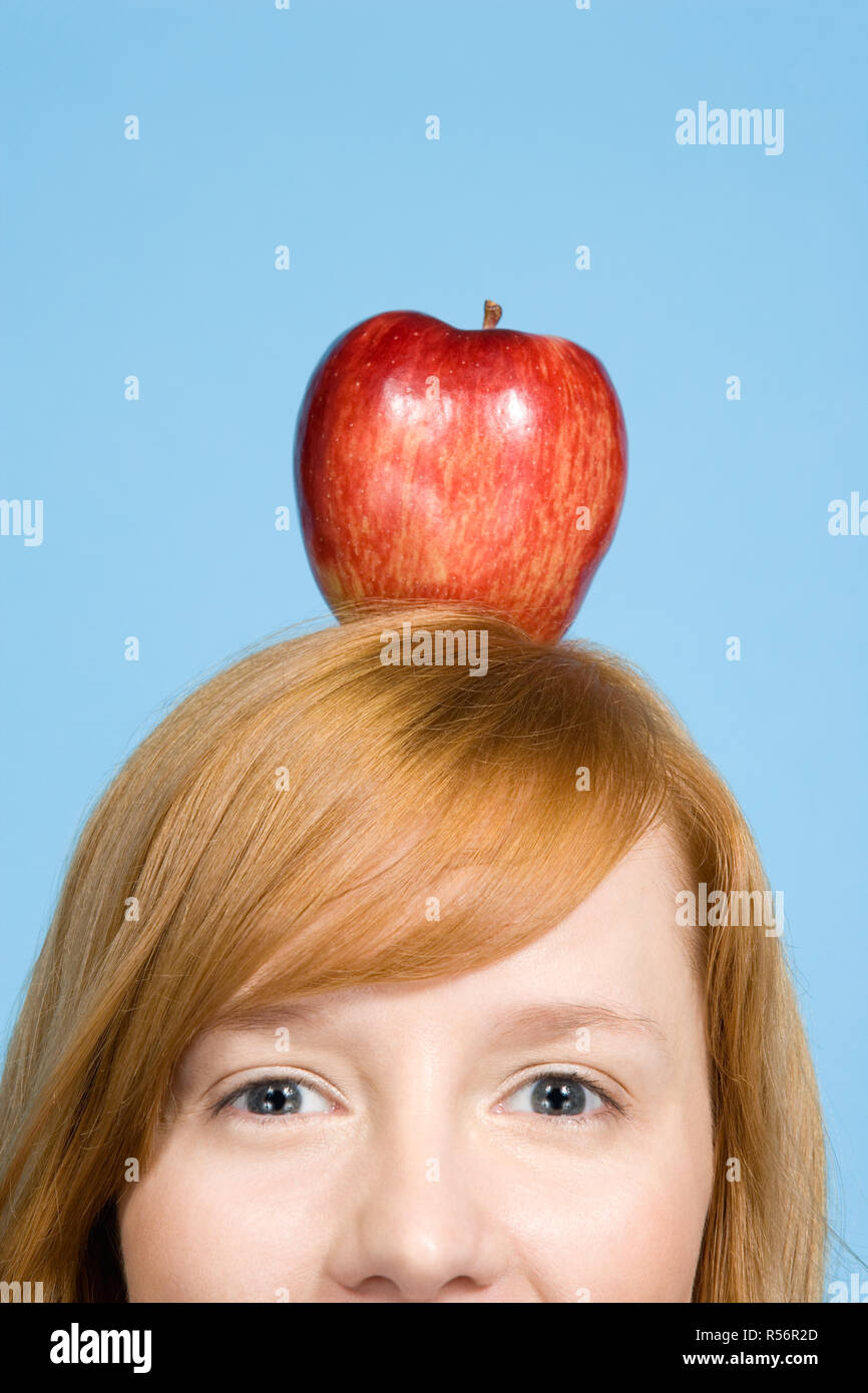 Femme avec une pomme sur le dessus de sa tête Banque D'Images