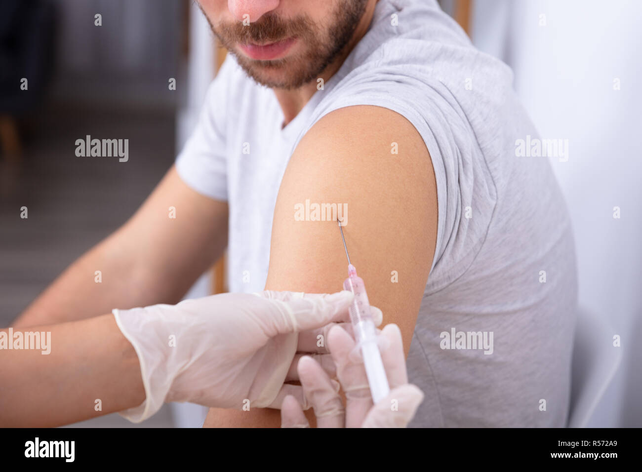 Close-up of a main du médecin du patient par injection avec seringue Banque D'Images