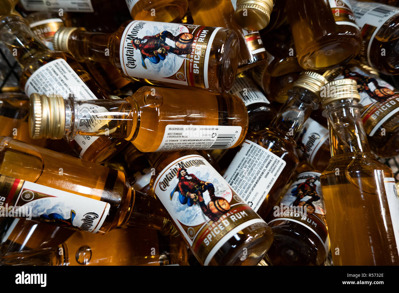 Un panier plein de bouteilles miniatures de rhum épicé Original Captain Morgan à vendre dans un magasin d'alcool. Banque D'Images