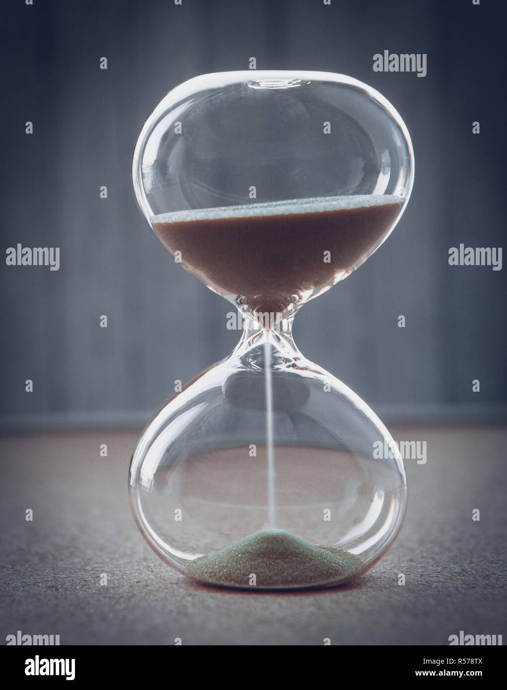 La mesure d'Hourglass passant du temps dans un compte à rebours jusqu'à une date limite, sur un arrière-plan flou with copy space Banque D'Images