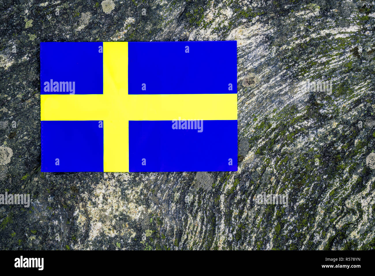 Drapeau national suédois sur fond de roches moussues. La nature scandinave. Banque D'Images