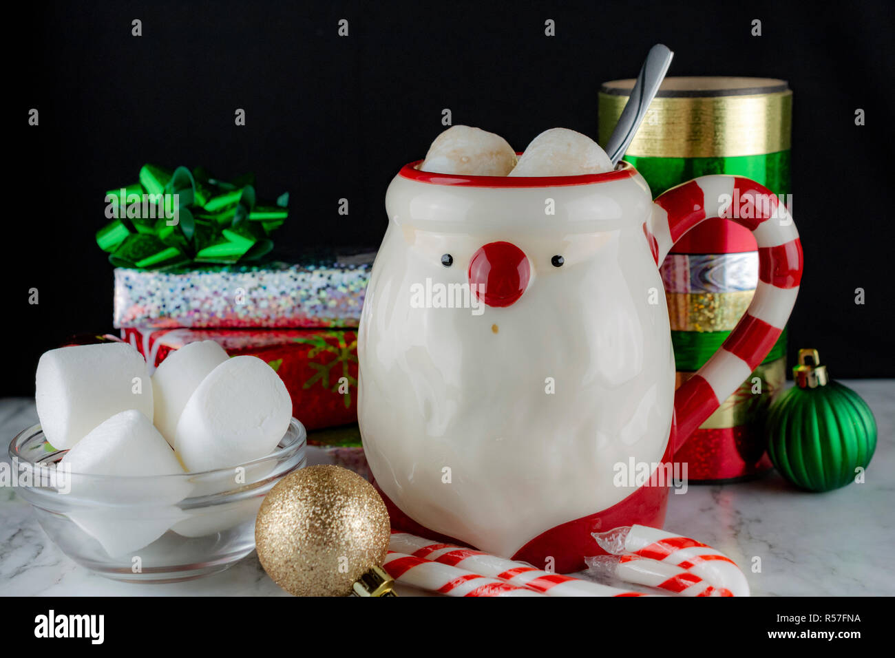 Santa Claus Mug avec du chocolat chaud & Marshmellows avec les cannes et bâtons de menthe fraîche et arcs Satin présente Marshmellows Banque D'Images