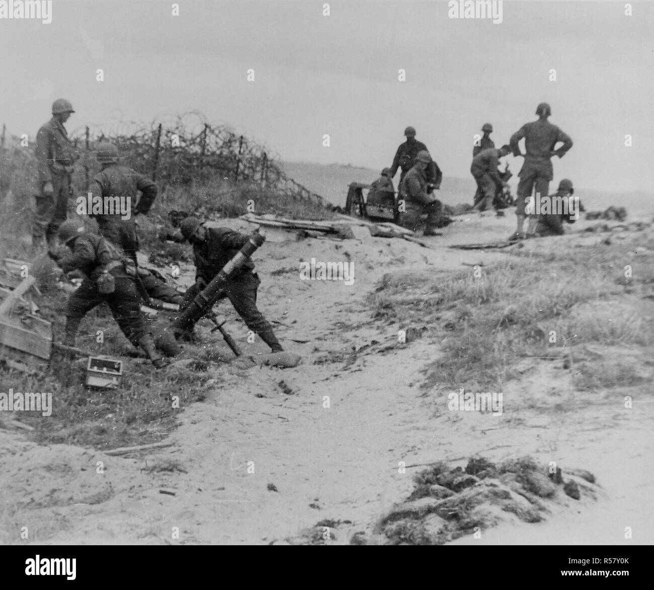 Un équipage de mortier se tient en retrait juste avant de tirer dans une position nazie quelque part le long de la côte normande, en France. Banque D'Images