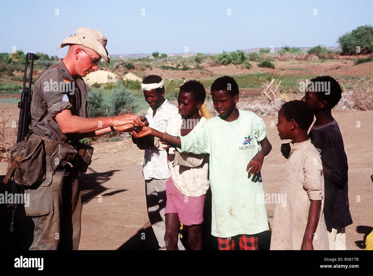 1993 - Un soldat allemand distribue des bonbons aux enfants somaliens dans la région de Belet Weyne. Le soldat fait partie du contingent des Nations Unies Appui à l'opération continue de l'espoir. Banque D'Images