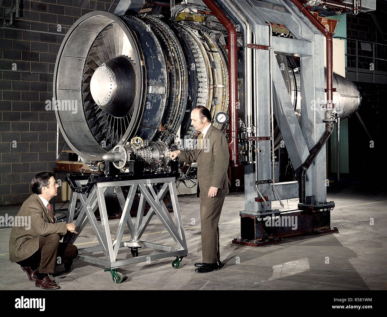 Les chercheurs Robert Cummings, gauche, et Harold l'or avec le petit moteur à faible coût dans l'ombre de la plus grande moteur silencieux à la National Aeronautics and Space Administration (NASA) Lewis Research Center. Banque D'Images