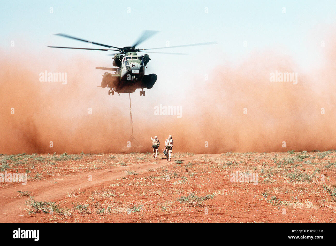 Un escadron d'hélicoptères lourds Marine 363 (HMH-363) CH-53D Sea Stallion helicopter offre un chargement de grain à un champ à la sortie du village d'Maleel au cours de l'effort de secours multinationales l'opération RESTORE HOPE. Le grain, donnés par l'Australie, est piloté dans au lieu de driven parce qu'il est soupçonné que les connaissements des routes du village ont été exploités. Banque D'Images